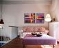 Preview: Gemütliche Sitzecke vor heller Wand mit einem abstrakten Wandbild als Dekoration