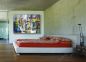 Preview: Schlafzimmer, helle Wand und langes Sofa. Dekoration interessantes Gemälde von Americo Ccala