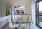 Preview: Modernes Esszimmer mit Glastisch. Zur Dekoration hängt ein maritimes Bild mit Schattenfugenrahmen an der Wand