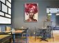 Preview: Restaurant mit einem abstrakten, bunt gemalten Wandbild. Afrikanerin im Bilderrahmen.