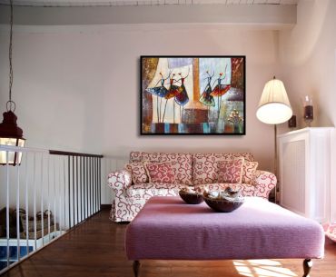 Sitzecke mit einem hellen Sofa und abstrakten, fröhlichen Motiv im Bilderrahmen