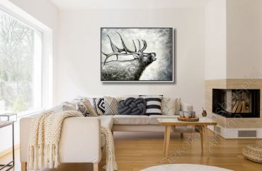 Helles Wohnzimmer mit Kamin. An der Wand hängt ein Hirsch mit Geweih, modern gemalt.