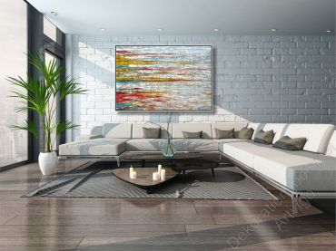 Sitzecke mit vielen warmen Farben. Über dem Sofa hängt ein großes eingerahmtes Bild als Dekoration