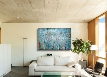 Sitzecke mit vielen warmen Farben. Über dem Sofa hängt ein großes eingerahmtes Bild als Dekoration