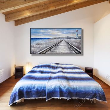 Gemütliches Schlafzimmer. Über dem Bett hängt ein Kunstwerk von einer weiten Küste