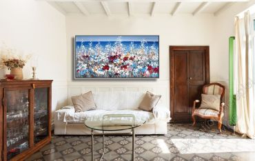 Gemütliches Wohnzimmer. Über dem Sofa hängt ein Kunstwerk von einer farbenfrohen Küste