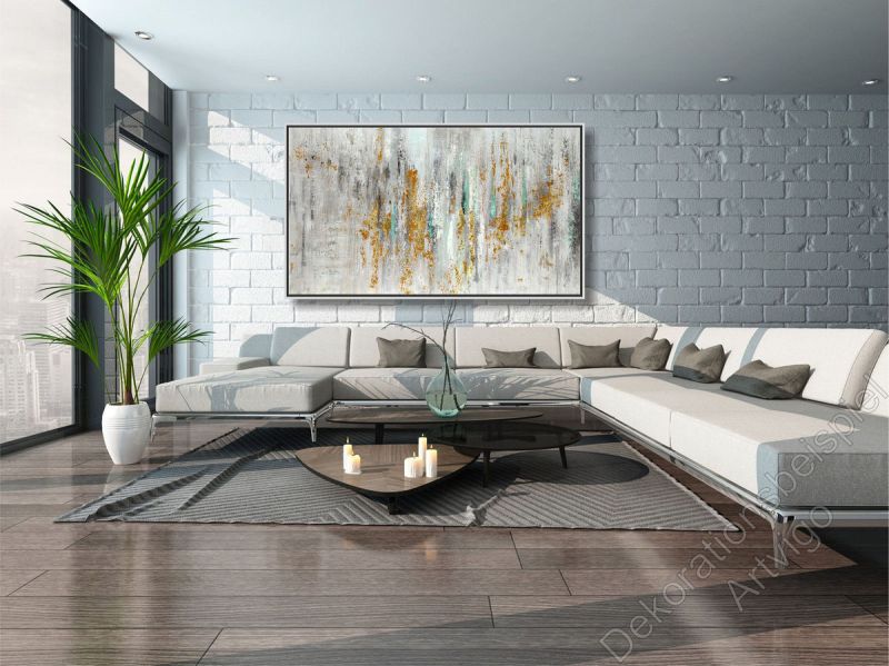 Sitzecke mit vielen warmen Farben. Über dem Sofa hängt ein großes eingerahmtes Bild als Dekoration