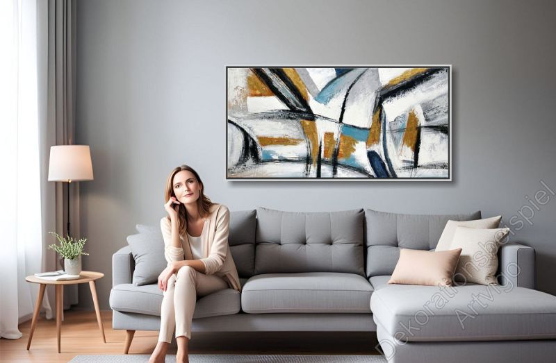 Sitzecke mit vielen warmen Farben. Über dem Sofa hängt ein großes eingerahmtes Bild als Dekoration