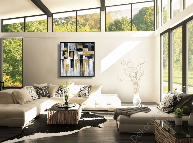 Heller Raum. Zur Dekoration hängt ein gegenstandsloses Bild mit Schattenfugenrahmen an der grauen Wand