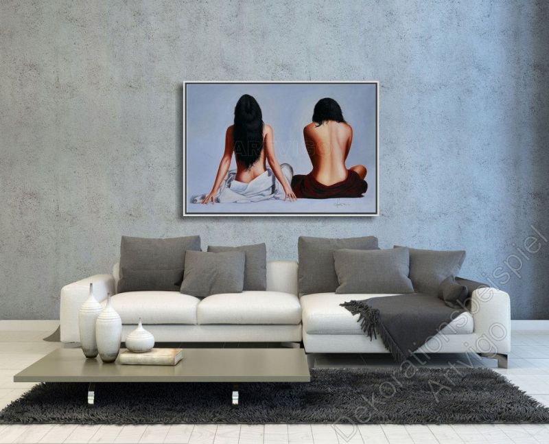 Modernes Wohnzimmer mit hellem Sofa. Als Dekoration über der Couch hängt ein eingerahmtes Bild. Frauen mit nacktem Rücken.