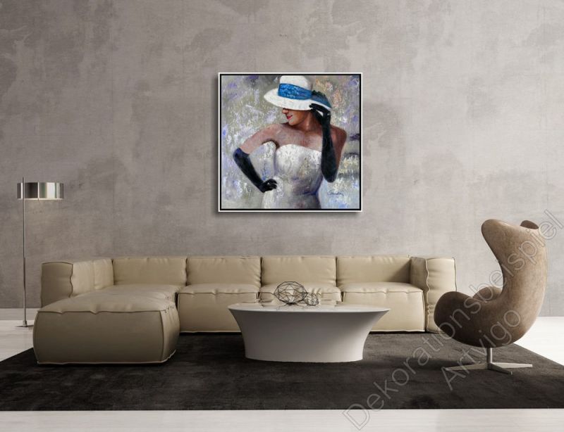 Wohnzimmer mit einer grauen Wand. Dekorationsbeispiel ein eingerahmtes Bild Frau mit Hut