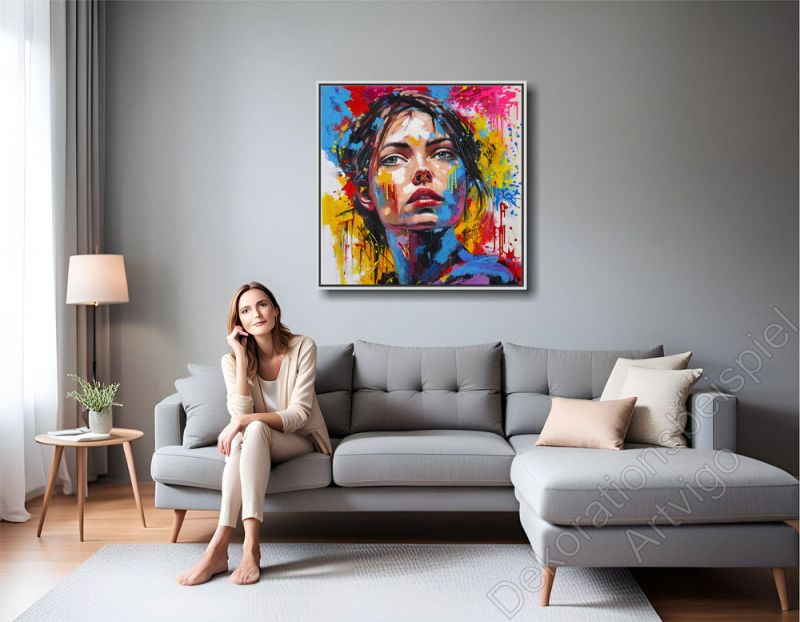 Stylishes Wohnzimmer. Als Hingucker hängt ein farbenfrohes Portrait mit Schattenfugenrahmen über dem Sofa