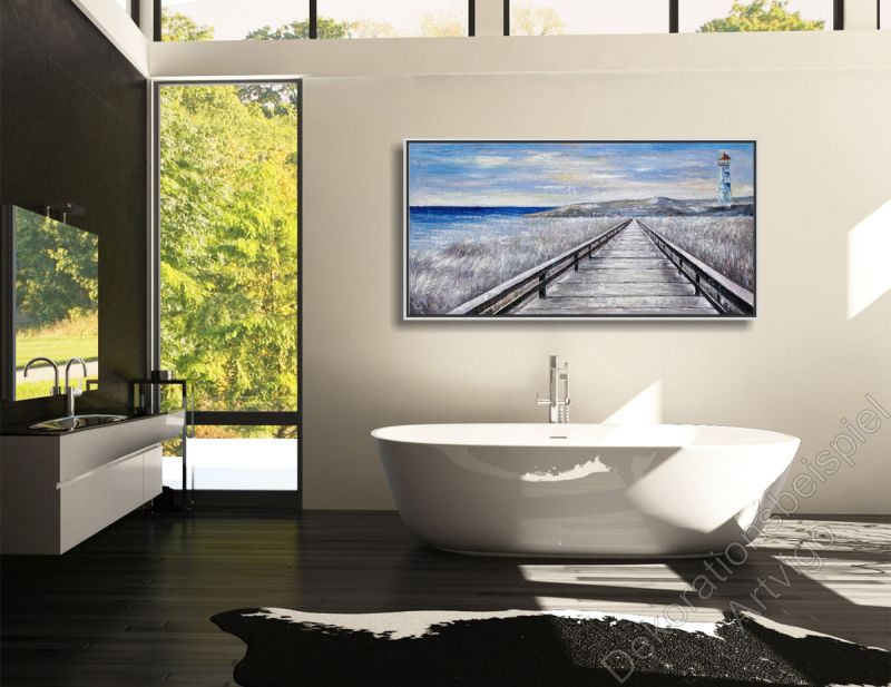 Badezimmerzimmer mit freistehender Wanne. An der Wand hängt ein Ölgemälde mit Meer und Leuchtturm im Bilderrahmen