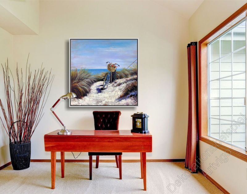 Arbeitszimmer mit einem roten Schreibtisch und sonnigem, unaufgeregten Strandbild in Bilderrahmen