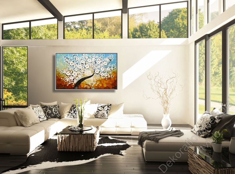 Wintergarten mit Sofa vor einer hellen Wand. Dekorationsbeispiel ein eingerahmtes Bild Kirschblüte
